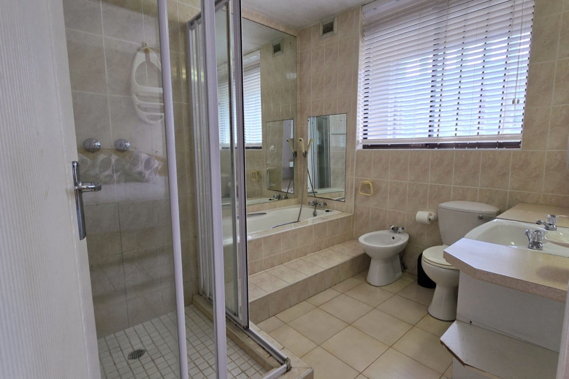 Large ensuite bathroom with walk-in shower and a bath off of the main bedroom in C Front 11 self-catering penthouse.