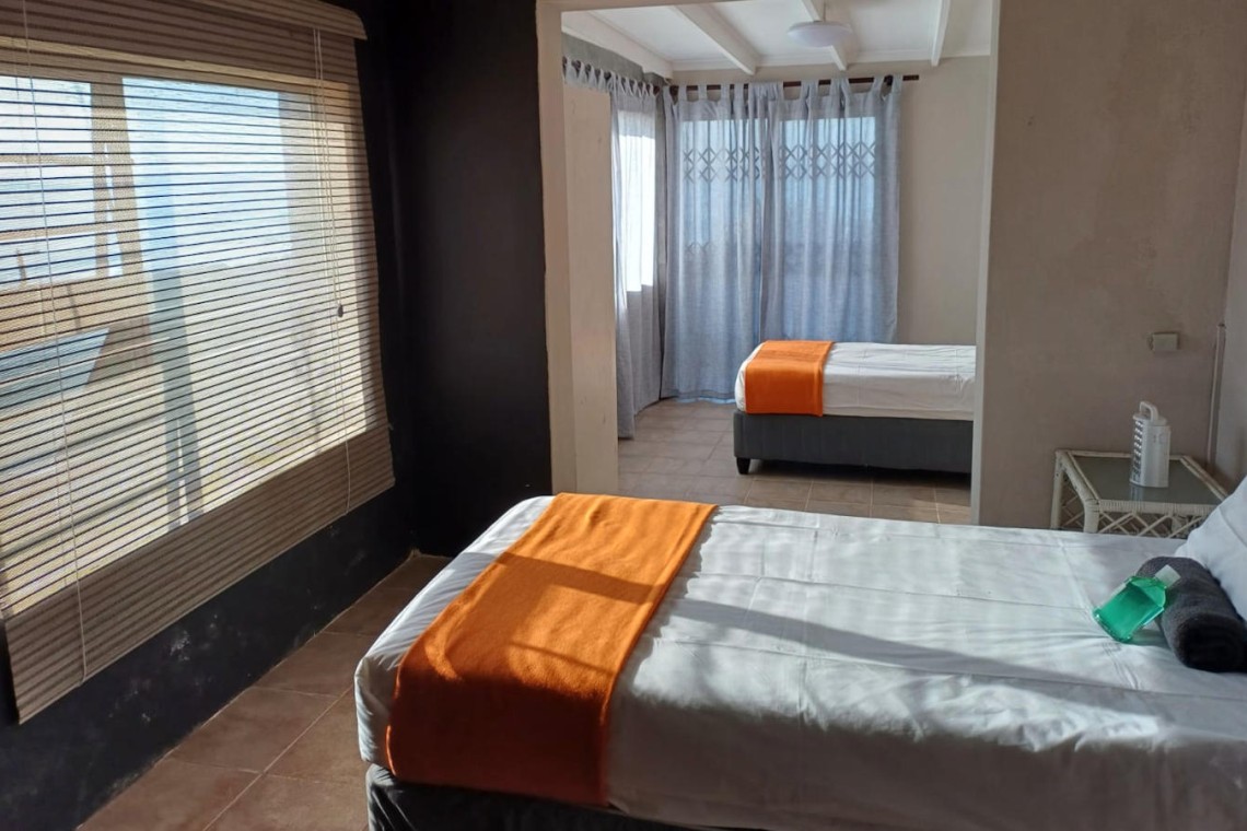 Sea Park House, the left wing downstairs bedroom with door to patio, garden and swimming pool in holiday home with sea view in KwaZulu Natal