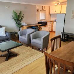 Sea Park House, the right wing lounge with door to patio, garden and swimming pool in holiday home with sea view in Sea Park on the South Coast of KwaZulu Natal