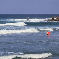 Children body-boarding at Uvongo Beach, just steps from Topanga 25 – a beachfront holiday rental in Uvongo ideal for families looking for fun in the surf.