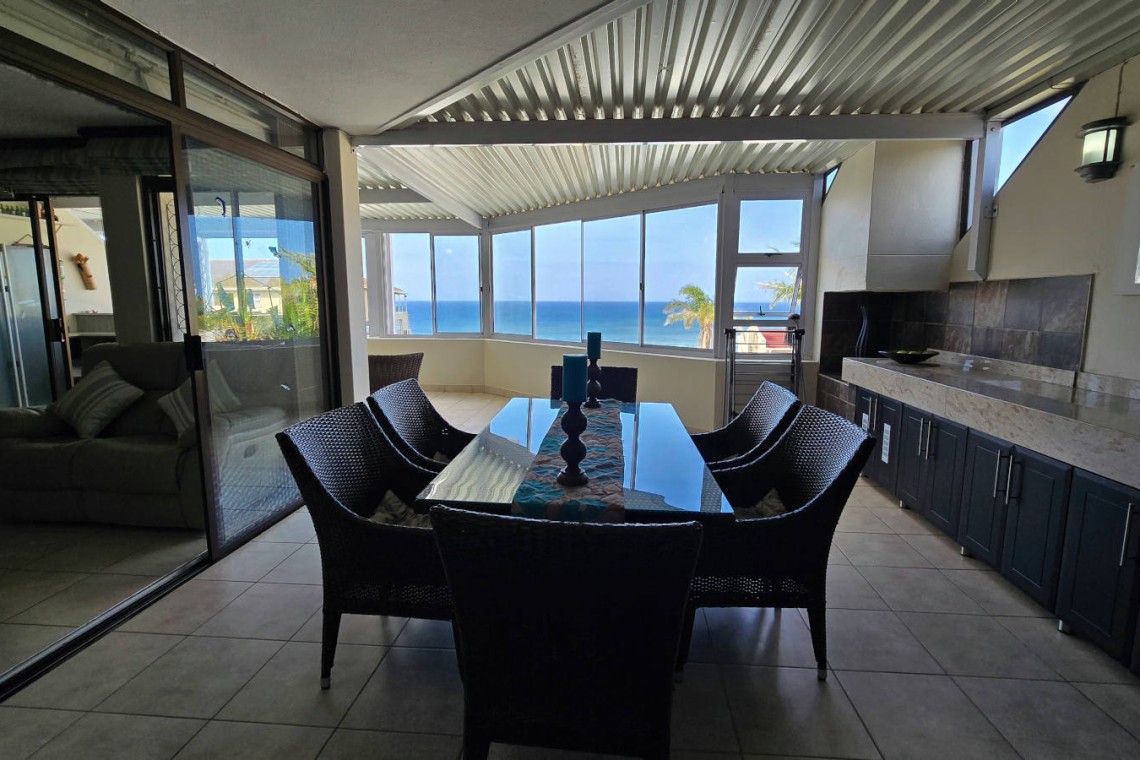 The dining table on the enclosed patio with sea view at Chardonnay Cabanas 5