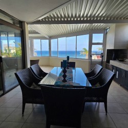 The dining table on the enclosed patio with sea view at Chardonnay Cabanas 5