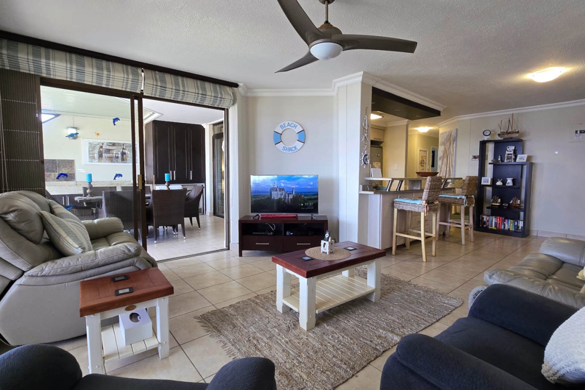 Open plan lounge leads onto kitchen and patio with sea view at Chardonnay Cabanas 5