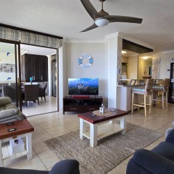 Open plan lounge leads onto kitchen and patio with sea view at Chardonnay Cabanas 5